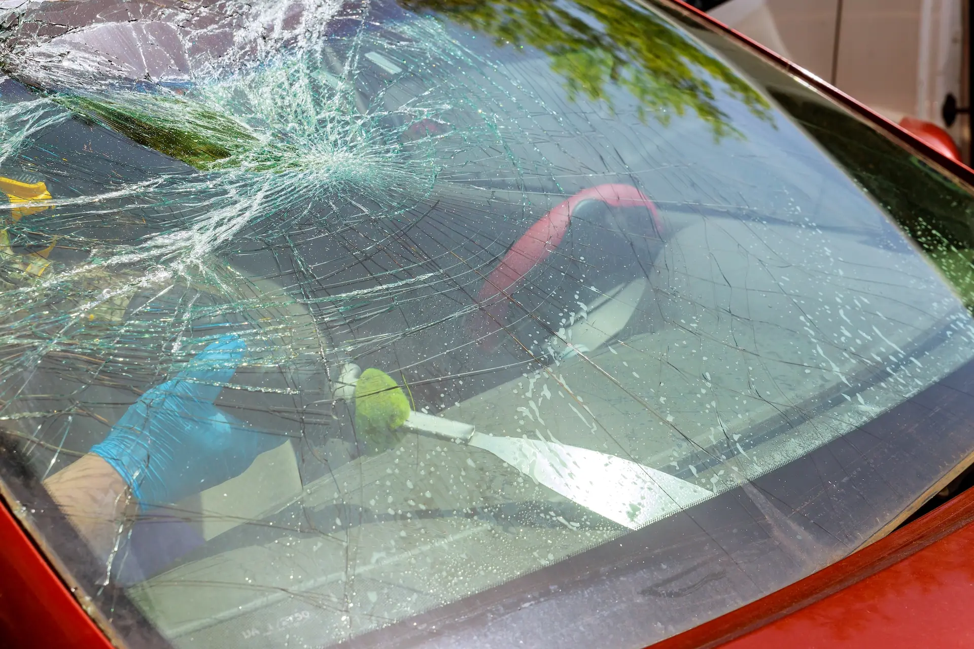 Technician removing a damaged windshield before installing a new one